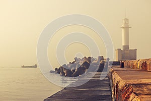 Sea sunrise. Foggy morning over the harbour and sailing fishing boat