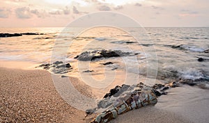 Sea sunrise with rocks on beach