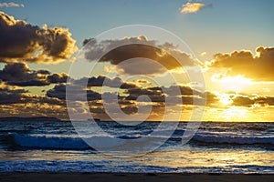 Sea at sunset with cargo ship on horizon