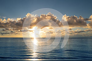 Sea sunset with cloudy sky and sun through the clouds over. Clouds Ocean and sky background, seascape.