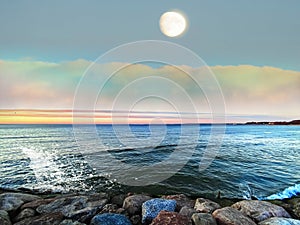 Sea sunset colorful evening sky and moon on cloudy skyline, light reflection on seawater,  summer