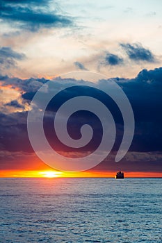 Sea sunset landscape with ship on the horizon