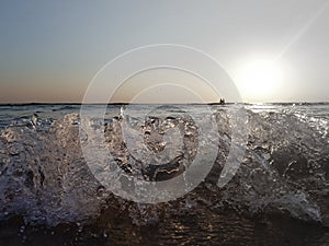 Sea sunset. Surf waves in the light of the setting sun.