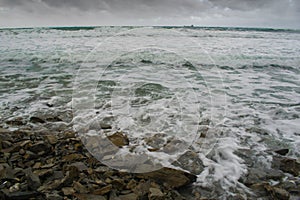 Sea surf on a stormy wind, rolling waves on coastal rocks