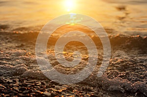 Sea surf on sunset time. Black Sea coast. Pebble washed by sea waves