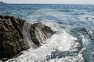 Sea surf. Waves breaking on a rock in the water. Sea foam. photo