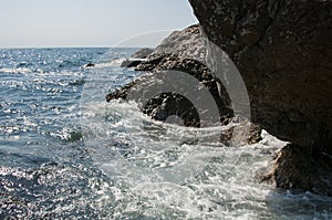 Sea surf. Waves breaking on a rock in the water. Sea foam. photo