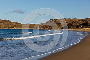 Sea surf, waves on the coast of the Barents Sea in autumn in sunny weather. Kola Peninsula, Russia