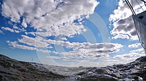 Sea surface and sailing boat from an action camera. Right on the edge of the sea surface.