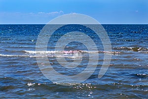 Sea surface with waves against the blue sky with clouds. Water cloud horizon background.