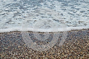 SEA TIDE ON THE PEBBLE BEACH AT SUN LIGHT, BEAUTY OF NATURE, SMALL STONES WITH WATER WAVE IN SUN LIGHT.pebble stones on
