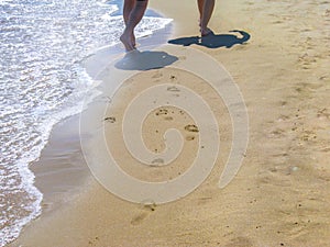 The sea transparent clear wave gradually washes away traces on the sand left by happy people