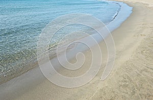 Sea transparent water on wet sand. Empty sandy beach, Greek island Cyclades, Greece. Space, top view