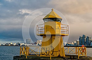 Sea transportation and navigation. Lighthouse on sea pier in reykjavik iceland. Lighthouse yellow bright tower at sea