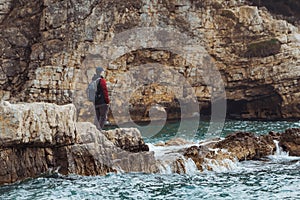 sea travel concept man at cliff with storming windy weather