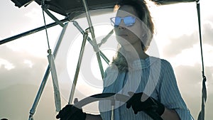 Sea travel, summer vacation of a lady skipper. Young woman sails a white yacht in the Caribbean sea.