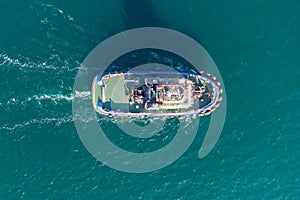 The sea tug moves from the port water area towards the open sea. Photo from the helicopter. View from above
