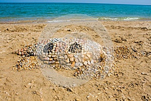 Sea turtle made of sand on the beach, Adriatic Seacoast view.