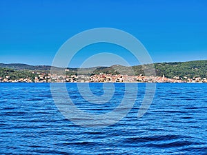 Sea view of the coast. Skiathos port on a brilliant summers day. Atlantic ocean shore, waves and sky. Boat or yacht on the