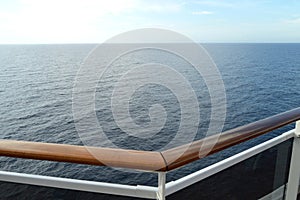 Sea view from the open deck of a modern cruise ship, railing and strong glass wall.