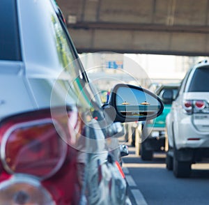 Sea view in side mirror of car with traffic jam