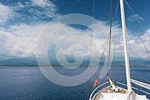 A sea voyage on a yacht. Island and cloudy sky in the background