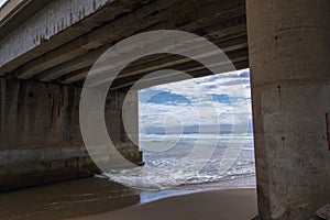 Sea Water Flowing into River at Low Tide under Railway Bridge