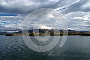 Sea water at mountain coast under cloudy sky in Rejkjavik, Iceland. Sea on mountain landscape. Beauty of wild nature