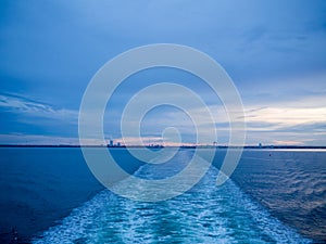 Sea water movement from ship sailing, sunset light