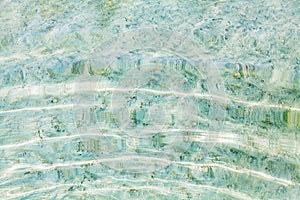Sea water ripples texture, water waves surface, transparent light blue ocean water top view, clear aqua background, underwater