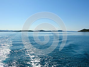 Sea water ship trail with white foamy wave. Tropical islands ferry travel. Bubble tail after cruise ship. Deep ocean view.