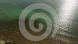 Sea water at springtime. Aerial top view of sandy beach and calm bay in spring