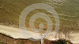 Sea water at springtime. Aerial top view of sandy beach and calm bay in spring