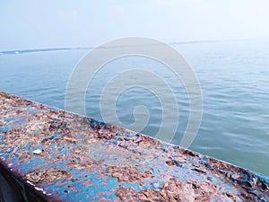 Sea water in the sun light beside a ferry boat.