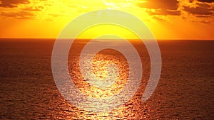 Sea water surface. Aerial view on golden sea water at sunset. Sun glare. Abstract nautical summer ocean nature. Holiday