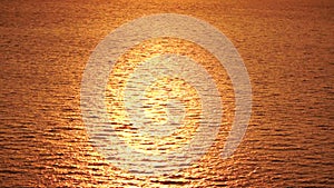 Sea water surface. Aerial view on golden sea water at sunset. Sun glare. Abstract nautical summer ocean nature. Holiday