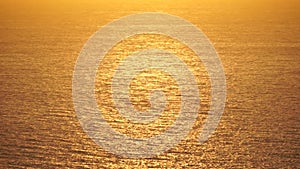 Sea water surface. Aerial view on golden sea water at sunset. Sun glare. Abstract nautical summer ocean nature. Holiday