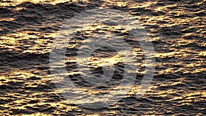 Sea water surface. Aerial view on golden sea water at sunset. Sun glare. Abstract nautical summer ocean nature. Holiday