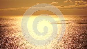 Sea water surface. Aerial view on golden sea water at sunset. Sun glare. Abstract nautical summer ocean nature. Holiday