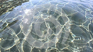 Sea water surface and ripples. Sun rays entering through water