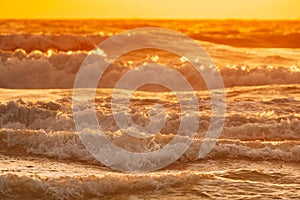 Sea water surface at sunset. Natural sunrise warm colors of ocean. Sea ocean water surface with foaming waves at sunset