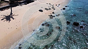 The sea water swashing over a beach with cream colored sand