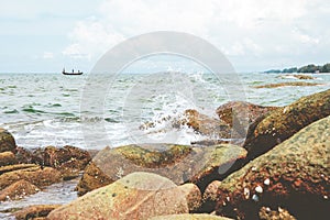 Sea water wave with stone rock of beach.