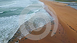 Sea water waves foaming sand close up. Stormy ocean surf washing seashell beach
