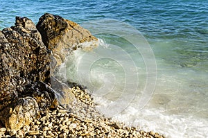 Sea wave is broken about stones.