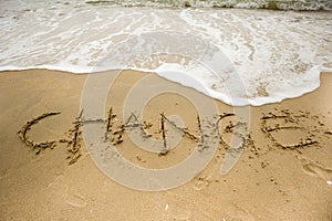 Sea wave with change texts on the sand