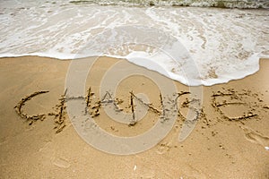 Sea wave with change texts on the sand photo