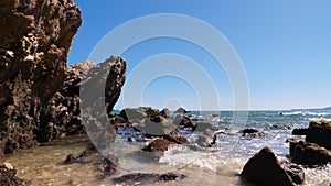 Sea wave coast to beach with stone and rock in the summer time