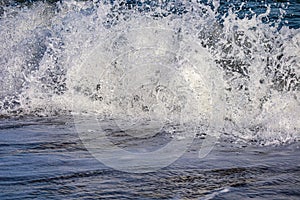 Sea wave crashing with splatter and spray ; Water splashing closeup.