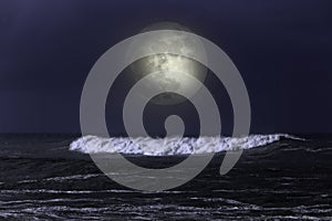 Sea wave in a dark full moon night